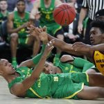 Oregon's Louis King, left, passes around Arizona State's De'Quon Lake during the first half of an NCAA college basketball game in the semifinals of the Pac-12 men's tournament Friday, March 15, 2019, in Las Vegas. (AP Photo/John Locher)
