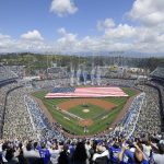 Fans stand for the national anthem before the opening day baseball game between the Los Angeles Dodgers and the Arizona Diamondbacks, Thursday, March 28, 2019, in Los Angeles. (AP Photo/Mark J. Terrill)