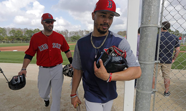Boston Red Sox center fielder Mookie Betts, foreground, and right fielder J.D. Martinez, walk off a...