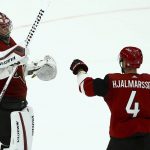 Arizona Coyotes goaltender Darcy Kuemper (35) celebrates his shutout against the Calgary Flames with defenseman Niklas Hjalmarsson (4) at the end of an NHL hockey game Thursday, March 7, 2019, in Glendale, Ariz. The Coyotes won 2-0. (AP Photo/Ross D. Franklin)
