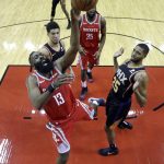 Houston Rockets' James Harden (13) shoots as Phoenix Suns' Mikal Bridges (25) and Devin Booker, left, defend during the first half of an NBA basketball game Friday, March 15, 2019, in Houston. (AP Photo/David J. Phillip)