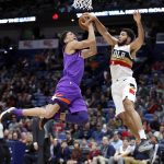 Phoenix Suns guard Devin Booker (1) is blocked by New Orleans Pelicans guard Kenrich Williams (34) during the first half of an NBA basketball game in New Orleans, Saturday, March 16, 2019. (AP Photo/Tyler Kaufman)