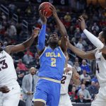 UCLA's Cody Riley, center, grabs a rebound over Arizona State's Romello White, left, and Kimani Lawrence, right, during the first half of an NCAA college basketball game in the quarterfinals of the Pac-12 men's tournament Thursday, March 14, 2019, in Las Vegas. (AP Photo/John Locher)