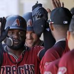 Arizona Diamondbacks' Abraham Almonte, left, is followed by Matt Szczur for congratulations in the dugout after they scored in the seventh inning of a spring training baseball game against the San Francisco Giants, Thursday, March 14, 2019, in Scottsdale, Ariz. (AP Photo/Elaine Thompson)