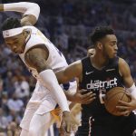 Washington Wizards forward Troy Brown Jr. (6) rips down a rebound away from Phoenix Suns forward Richaun Holmes during the first half of an NBA basketball game Wednesday, March 27, 2019, in Phoenix. (AP Photo/Ross D. Franklin)