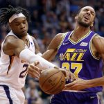 Phoenix Suns forward Richaun Holmes, left, fouls Utah Jazz center Rudy Gobert during the first half of an NBA basketball game Wednesday, March 13, 2019, in Phoenix. (AP Photo/Matt York)
