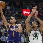 Phoenix Suns guard Devin Booker (1) lays up the ball as Utah Jazz center Rudy Gobert (27) defends during the first half of an NBA basketball game Monday, March 25, 2019, in Salt Lake City. (AP Photo/Rick Bowmer)