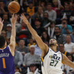 Phoenix Suns guard Devin Booker (1) shoots as Utah Jazz center Rudy Gobert (27) defends during the second half of an NBA basketball game Monday, March 25, 2019, in Salt Lake City. (AP Photo/Rick Bowmer)