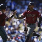 Arizona Diamondbacks' Ketel Marte, right, celebrates with Jake Lamb after both scoring off a two-run double by Nick Ahmed during the fourth inning of an MLB baseball game against the Los Angeles Dodgers in Los Angeles, Sunday, March 31, 2019. (AP Photo/Kelvin Kuo)