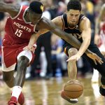 Houston Rockets' Clint Capela (15) and Phoenix Suns' Devin Booker reach for a loose ball during the second half of an NBA basketball game Friday, March 15, 2019, in Houston. The Rockets won 108-102. (AP Photo/David J. Phillip)