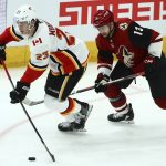Calgary Flames center Sean Monahan (23) looks to pass the puck as Arizona Coyotes center Vinnie Hinostroza (13) defends during the third period of an NHL hockey game Thursday, March 7, 2019, in Glendale, Ariz. The Coyotes defeated the Flames 2-0. (AP Photo/Ross D. Franklin)