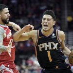 Phoenix Suns' Devin Booker (1) pushes off against Houston Rockets' Austin Rivers during the first half of an NBA basketball game Friday, March 15, 2019, in Houston. (AP Photo/David J. Phillip)
