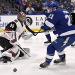 Arizona Coyotes goaltender Darcy Kuemper (35) deflects a shot as Tampa Bay Lightning center Brayden Point (21) looks for the rebound during the second period of an NHL hockey game Monday, March 18, 2019, in Tampa, Fla. (AP Photo/Jason Behnken)