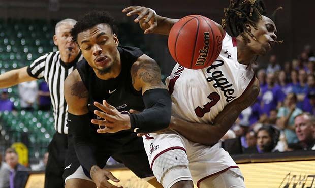 Grand Canyon's Carlos Johnson, left, fouls New Mexico State guard Terrell Brown as he tries to pick...