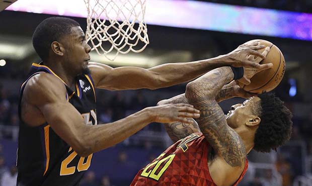 Atlanta Hawks forward John Collins (20) is fouled by Phoenix Suns forward Josh Jackson, left, durin...