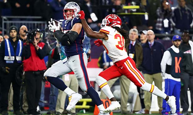 Rob Gronkowski #87 of the New England Patriots makes a catch while under pressure from Josh Shaw #3...