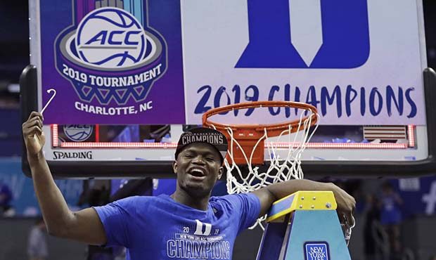 Duke's Zion Williamson celebrates Duke's win over Florida State after cutting a piece of a net afte...