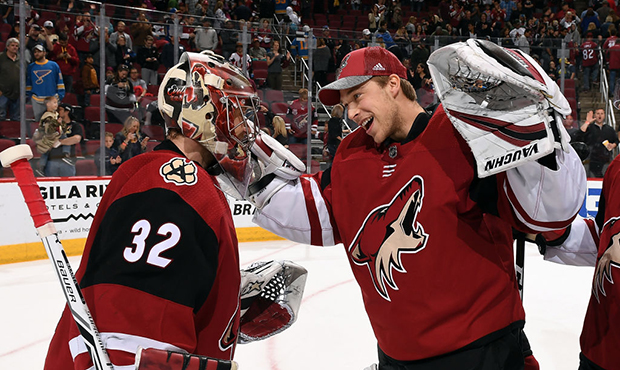 Goalie Antti Raanta #32 of the Arizona Coyotes is congratulated by teammate Darcy Kuemper #35 after...