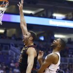 Cleveland Cavaliers forward Larry Nance Jr., left, shoots as he gets past Phoenix Suns forward Mikal Bridges, right, during the first half of an NBA basketball game Monday, April 1, 2019, in Phoenix. (AP Photo/Ross D. Franklin)