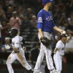 Texas Rangers starting pitcher Mike Minor, right, pauses on the mound after giving up a home run to Arizona Diamondbacks' Nick Ahmed, left, during the seventh inning of a baseball game Tuesday, April 9, 2019, in Phoenix. The Diamondbacks defeated the Rangers 5-4. (AP Photo/Ross D. Franklin)