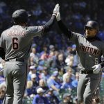 Arizona Diamondbacks' Eduardo Escobar, right, celebrates with David Peralta after hitting a solo home run against the Chicago Cubs during the first inning of a baseball game Saturday, April 20, 2019, in Chicago. (AP Photo/Nam Y. Huh)