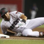 Arizona Diamondbacks' David Peralta dives safely back into first base after hitting a single against the Boston Red Sox during the first inning of a baseball game Friday, April 5, 2019, in Phoenix. (AP Photo/Ross D. Franklin)