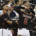 Arizona Diamondbacks' Eduardo Escobar (5) is congratulated by David Peralta, left, after scoring against the San Diego Padres during the sixth inning of a baseball game Saturday, April 13, 2019, in Phoenix. (AP Photo/Ross D. Franklin)