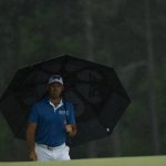 Charl Schwartzel, of South Africa, waits in the rain on the 18th hole during the second round for the Masters golf tournament Friday, April 12, 2019, in Augusta, Ga. (AP Photo/Matt Slocum)