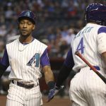 Arizona Diamondbacks' Jarrod Dyson, left, is congratulated by Ketel Marte after scoring against the San Diego Padres during the first inning of a baseball game Thursday, April 11, 2019, in Phoenix. (AP Photo/Ross D. Franklin)