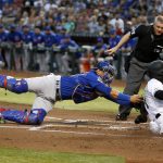 Arizona Diamondbacks' Ketel Marte, front right, slides across home plate to score a run on an RBI-double by teammate Adam Jones as Chicago Cubs catcher Willson Contreras, left, dives to apply a late tag during the first inning of a baseball game, Friday, April 26, 2019, in Phoenix. (AP Photo/Ralph Freso)