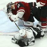 Arizona Coyotes goaltender Darcy Kuemper (35) grimaces in pain as he is hit in the face with the stick from Los Angeles Kings center Trevor Lewis (22) during the third period of an NHL hockey game, Tuesday, April 2, 2019, in Glendale, Ariz. The Kings defeated the Coyotes 3-1. (AP Photo/Ross D. Franklin)