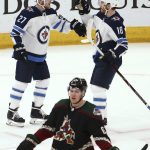 Winnipeg Jets left wing Nikolaj Ehlers (27) celebrates his goal against the Arizona Coyotes with center Bryan Little (18) as Coyotes left wing Lawson Crouse, bottom, skates past during the second period of an NHL hockey game Saturday, April 6, 2019, in Glendale, Ariz. (AP Photo/Ross D. Franklin)