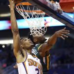 Phoenix Suns guard Elie Okobo (2) gets off a shot over Utah Jazz guard Donovan Mitchell, right, during the first half of an NBA basketball Wednesday, April 3, 2019, in Phoenix. (AP Photo/Ross D. Franklin)