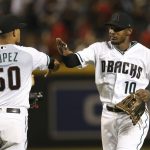 Arizona Diamondbacks center fielder Adam Jones (10) and relief pitcher Yoan Lopez (50) celebrate their win over the Boston Red Sox after a baseball game Friday, April 5, 2019, in Phoenix. (AP Photo/Ross D. Franklin)