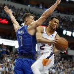 Dallas Mavericks' Dwight Powell (7) turns Phoenix Suns guard Elie Okobo (2) away on a shot attempt during the first half of an NBA basketball game in Dallas, Tuesday, April 9, 2019. (AP Photo/Tony Gutierrez)