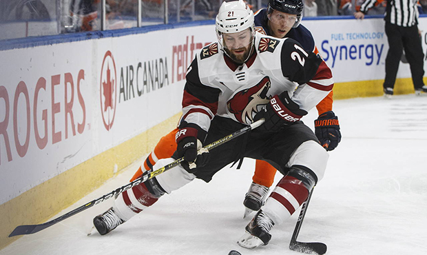 Arizona Coyotes' Derek Stepan (21) is checked by Edmonton Oilers' Alex Chiasson, rear, during the f...