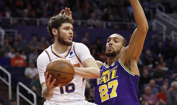 Phoenix Suns guard Tyler Johnson (16) looks to pass the ball as Utah Jazz center Rudy Gobert (27) d...