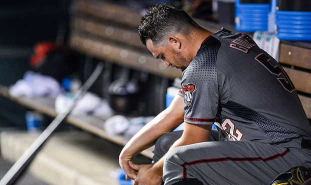 Zack Godley #52 of the Arizona Diamondbacks stretches his arm in the dugout after being relieved in...