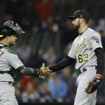 Oakland Athletics catcher Josh Phegley, left, and relief pitcher Lou Trivino shake hands after the ninth inning of a baseball game against the Detroit Tigers, Friday, May 17, 2019, in Detroit. (AP Photo/Carlos Osorio)
