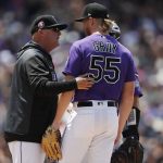 Colorado Rockies pitching coach Steve Foster, left, confers with starting pitcher Jon Gray after he walked Arizona Diamondbacks' Eduardo Escobar in the fourth inning of a baseball game Monday, May 27, 2019, in Denver. (AP Photo/David Zalubowski)