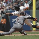 San Francisco Giants' Kevin Pillar, top, is tagged out by Arizona Diamondbacks third baseman Eduardo Escobar (5) while trying to reach third after doubling during the sixth inning of a baseball game in San Francisco, Saturday, May 25, 2019. (AP Photo/Jeff Chiu)