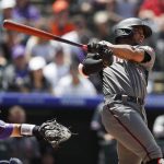 Arizona Diamondbacks' Ketel Marte, right, connects for a sacrifice fly to bring in a run as Colorado Rockies catcher Tony Wolters looks on in the fourth inning of a baseball game Monday, May 27, 2019, in Denver. (AP Photo/David Zalubowski)