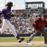 Arizona Diamondbacks starting pitcher Zack Greinke, right, fields the throw at first to put out Colorado Rockies' Charlie Blackmon after he hit a ground ball to Arizona first baseman Christian Walker in the third inning of a baseball game Sunday, May 5, 2019, in Denver. (AP Photo/David Zalubowski)