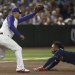Arizona Diamondbacks third baseman Eduardo Escobar, left, makes a catch before tagging out Atlanta Braves' Ozzie Albies at third base as Albies tried to stretch a double into a triple during the third inning of a baseball game Thursday, May 9, 2019, in Phoenix. (AP Photo/Ross D. Franklin)