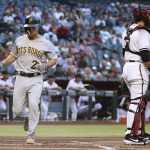 Pittsburgh Pirates' Adam Frazier, left, scores a run as Arizona Diamondbacks catcher Alex Avila, right, waits for a late throw during the first inning of a baseball game Monday, May 13, 2019, in Phoenix. (AP Photo/Ross D. Franklin)