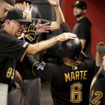 Pittsburgh Pirates' Starling Marte (6) is greeted in the dugout after scoring during the third inning of the team's baseball game against the Arizona Diamondbacks on Tuesday, May 14, 2019, in Phoenix. (AP Photo/Matt York)