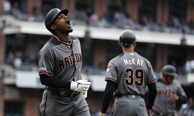 Arizona Diamondbacks' Adam Jones, left, reacts after flying out during the ninth inning of the team...