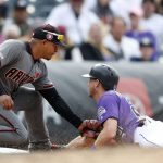 Arizona Diamondbacks third baseman Eduardo Escobar, left, tags out Colorado Rockies' Ryan McMahon, right,  who was trying to advance from second to third base on a pitch to end the 10th inning of a baseball game Monday, May 27, 2019, in Denver. (AP Photo/David Zalubowski)