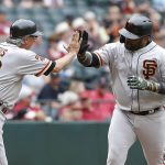 San Francisco Giants' Pablo Sandoval, right, is congratulated by third base coach Ron Wotus as he rounds the bases after hitting a pinch-hit home run against the Arizona Diamondbacks during the 10th inning of a baseball game, Sunday, May 19, 2019, in Phoenix. (AP Photo/Ralph Freso)