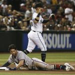 Atlanta Braves' Dansby Swanson, left, slides safely into third base with a triple as Arizona Diamondbacks third baseman Ildemaro Vargas, back, waits for a late throw during the fourth inning of a baseball game Friday, May 10, 2019, in Phoenix. (AP Photo/Ross D. Franklin)